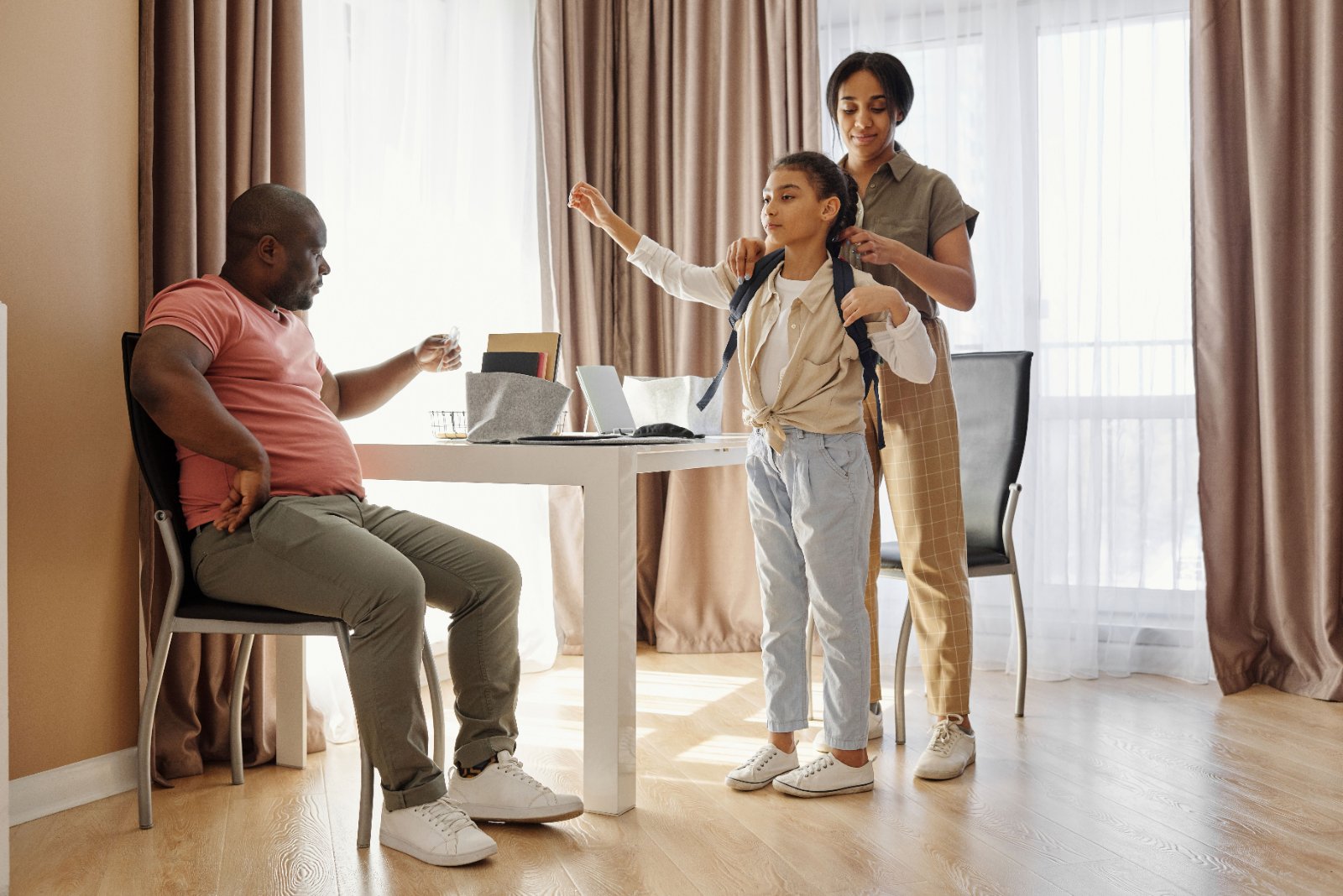 Black mother guiding her son as he washes his hands during a familiar home routine.