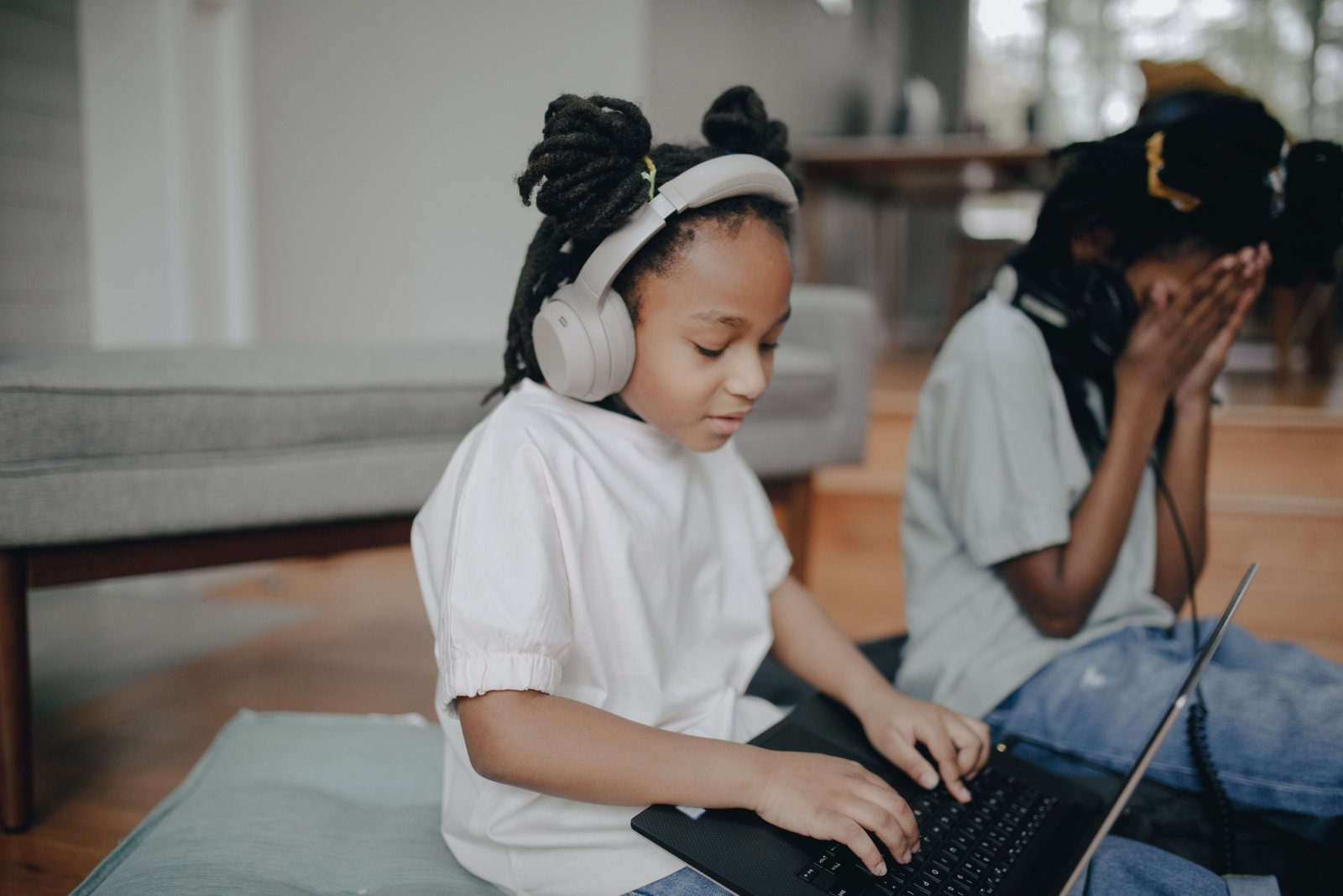 A young girl covering her ears in a noisy environment.