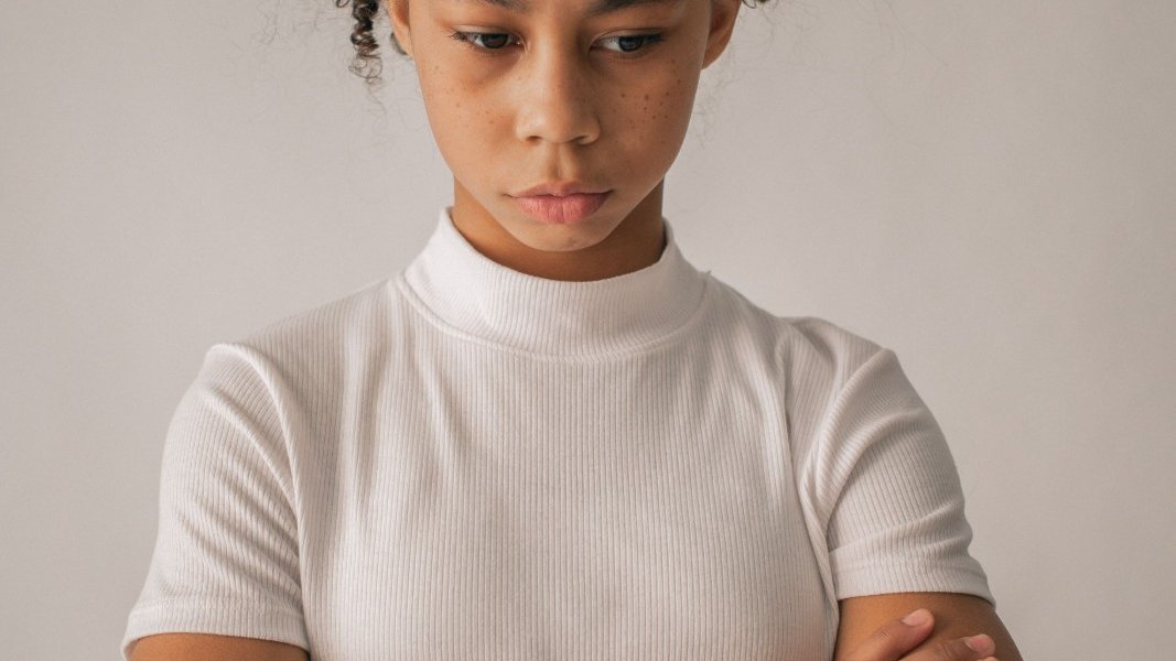 A young Black girl reflecting on her emotions.