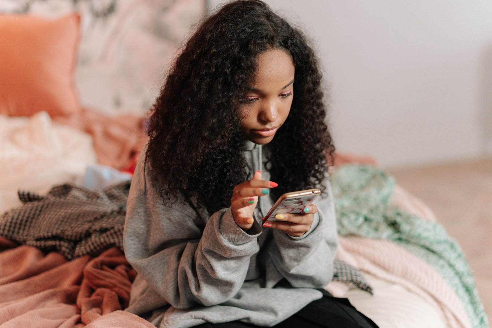 Black girl looking at her phone, reflecting on social media