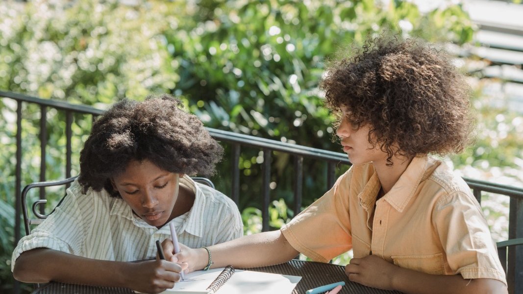 Group of Black girls sitting together, looking concerned.
