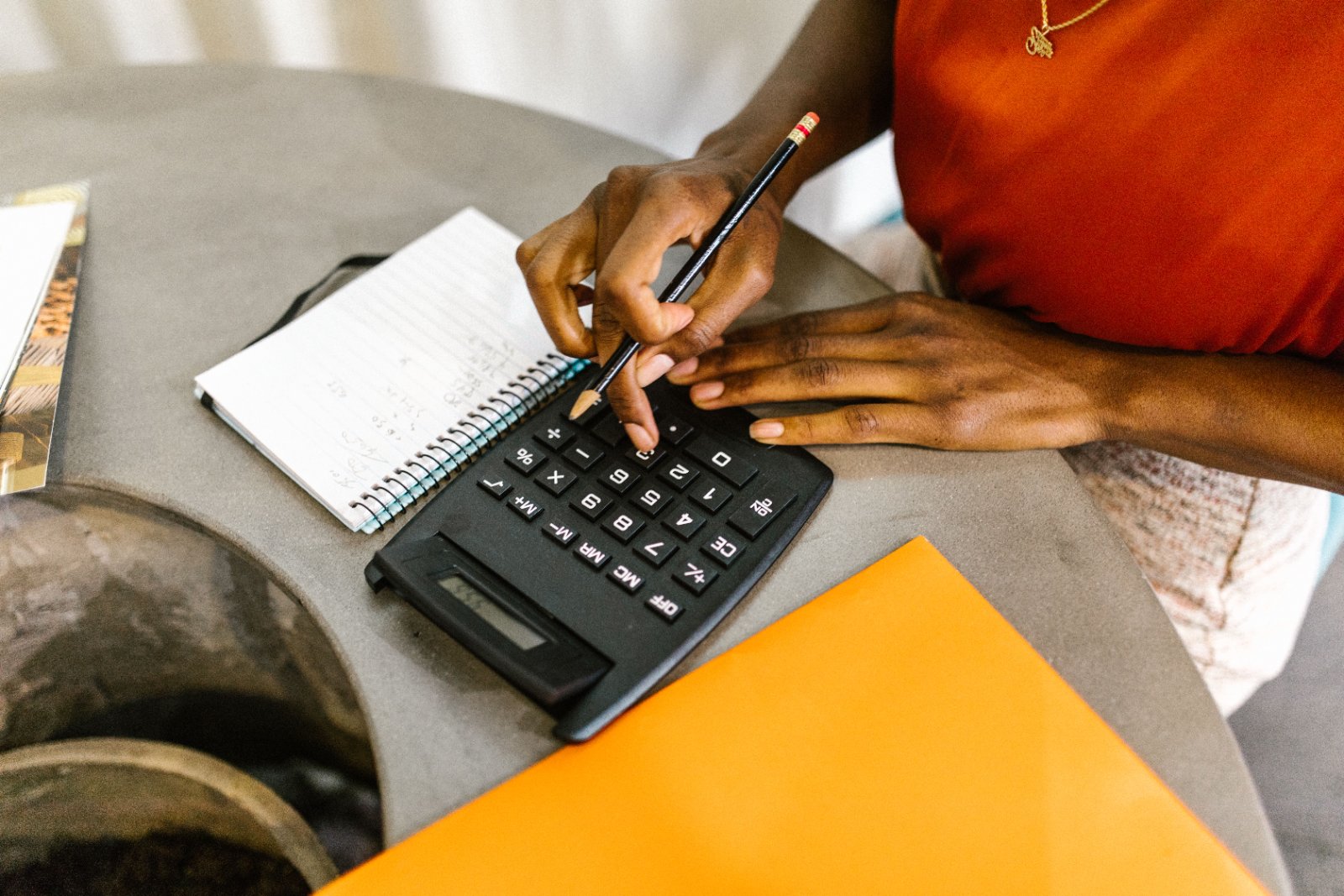 A woman reviewing her finances with a laptop and notepad.