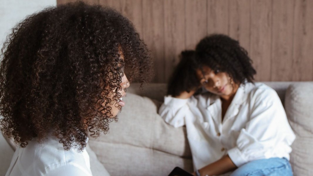 A diverse group of Black women engaging in a supportive discussion.