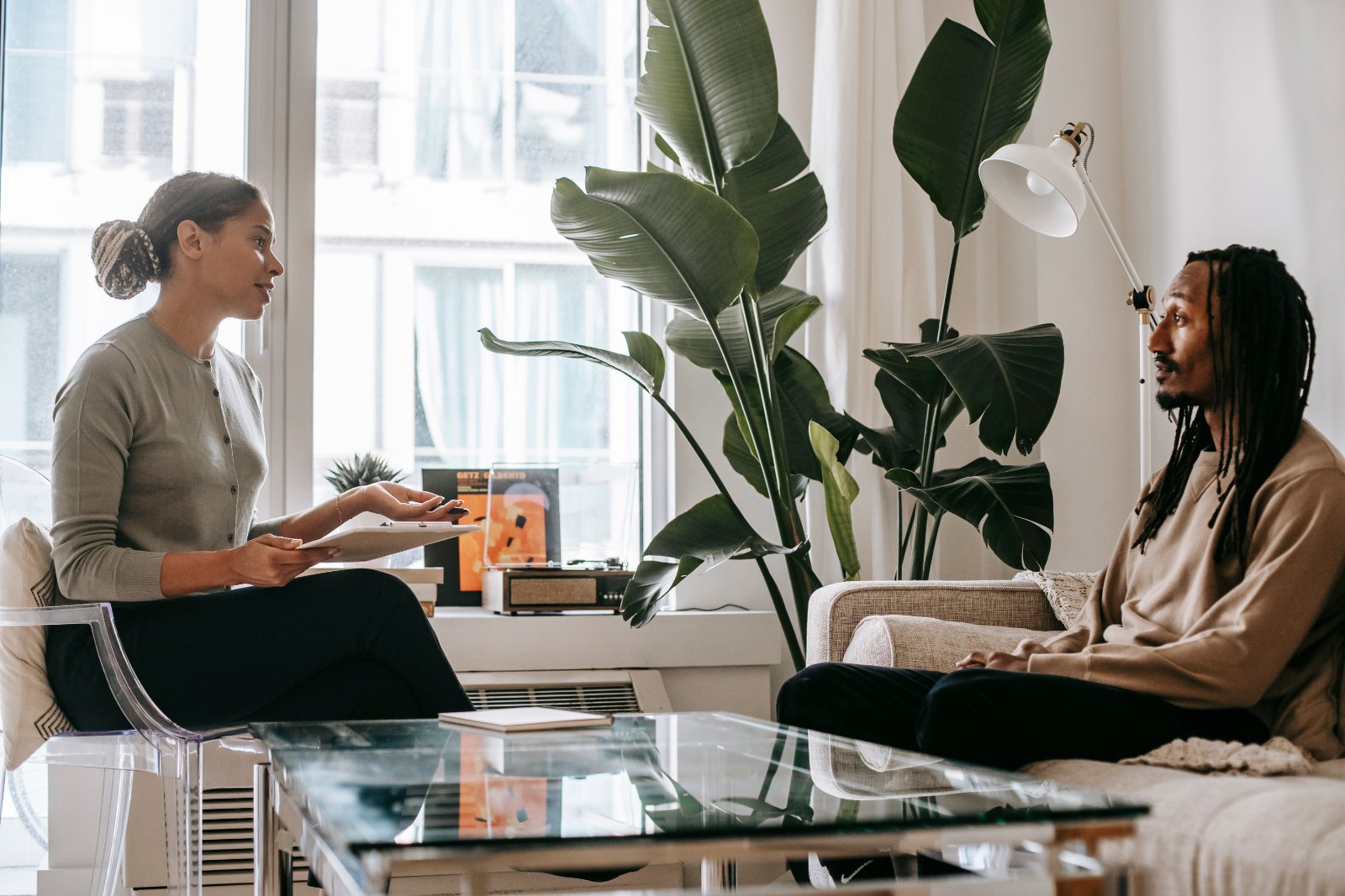 Black psychologist speaking with a Black adult during a professional consultation.