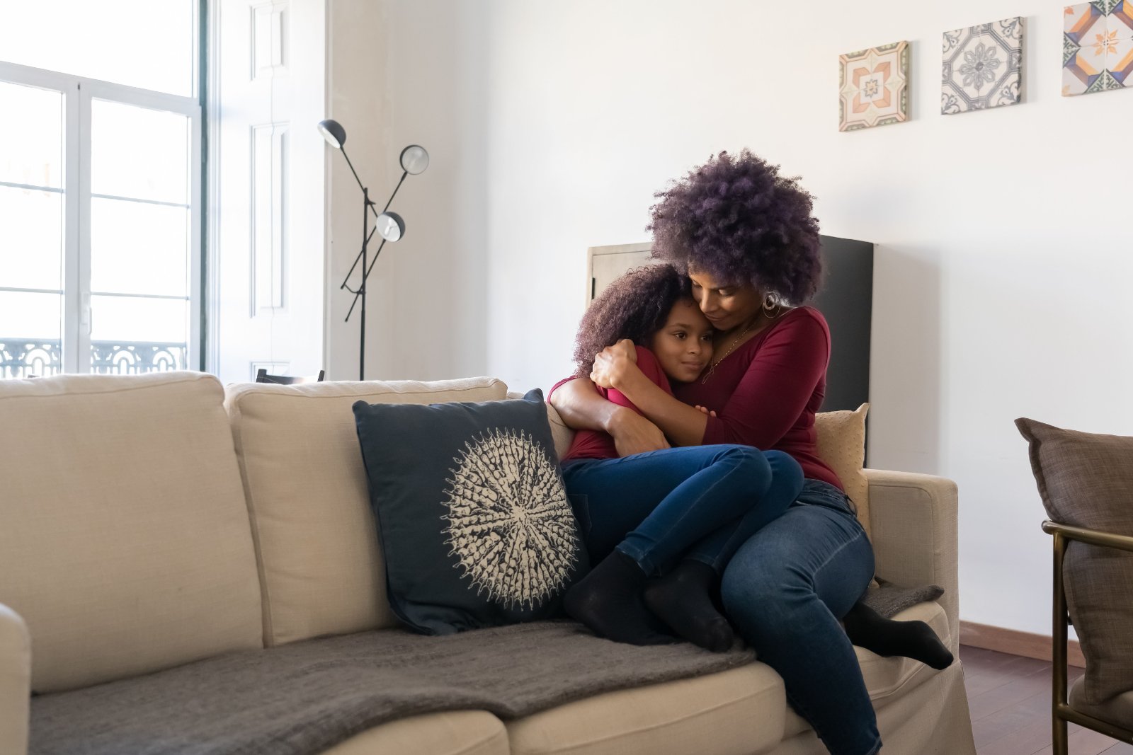 Black mother listening to her daughter during a calm conversation at home.